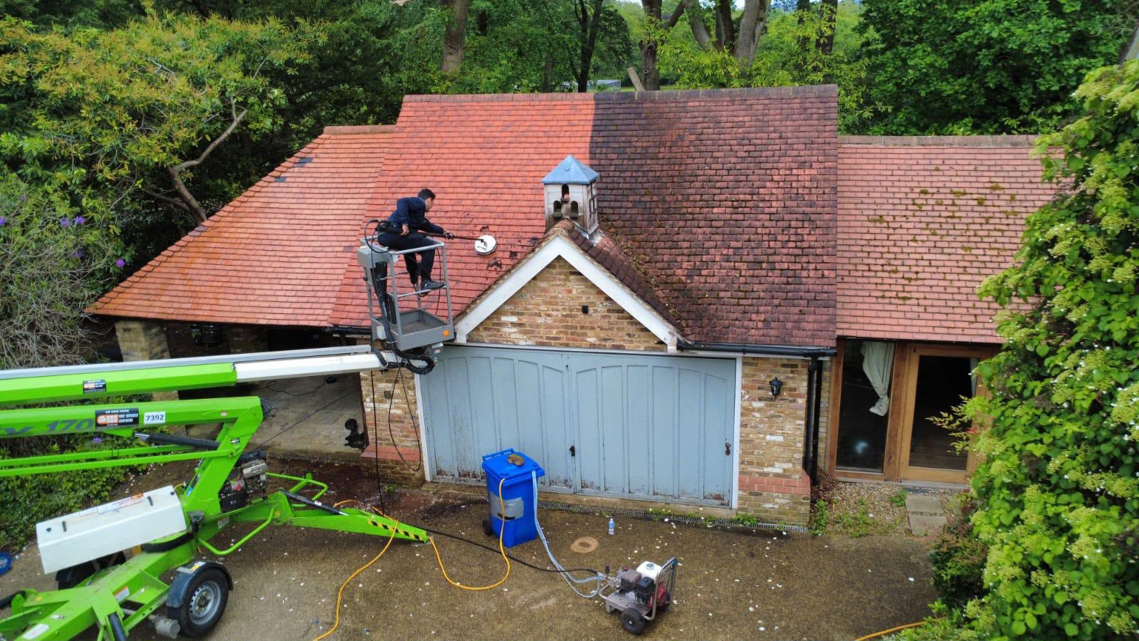 Roof cleaning in progress using specialist cherry picker access equipment